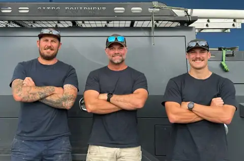 Three of the Woodward team in dark uniform shirts